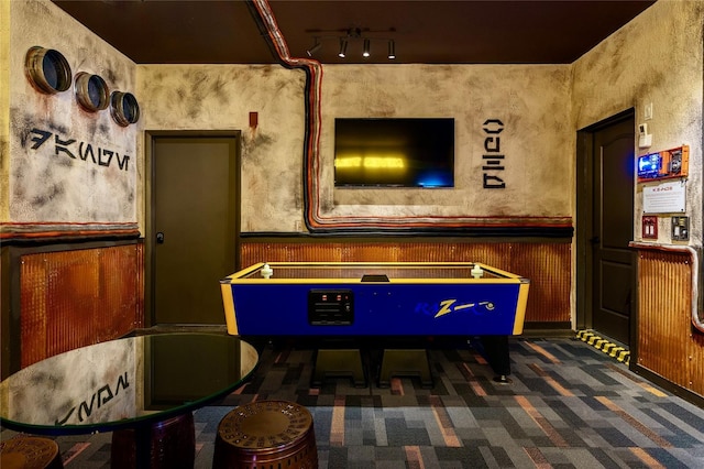 game room with dark colored carpet and rail lighting