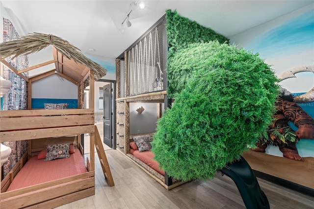 bedroom featuring track lighting and hardwood / wood-style floors