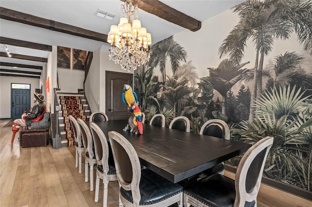 dining space featuring beamed ceiling, light hardwood / wood-style flooring, and an inviting chandelier