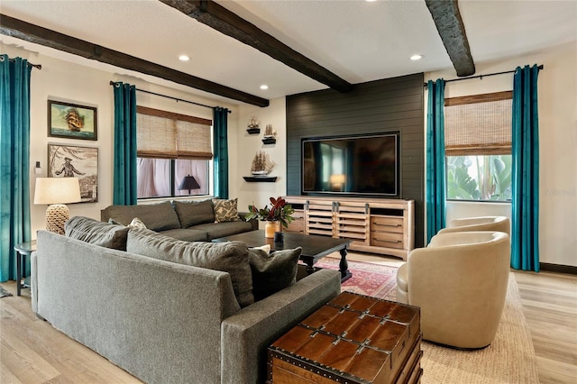 living room with beamed ceiling and light hardwood / wood-style flooring