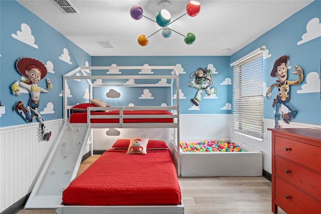 bedroom with light hardwood / wood-style floors and a textured ceiling