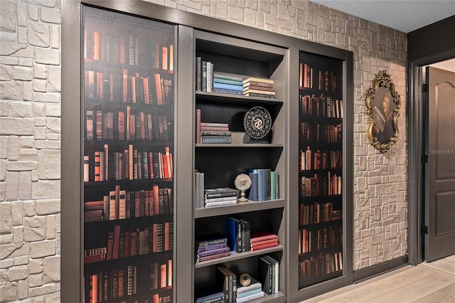 details featuring built in shelves and hardwood / wood-style flooring