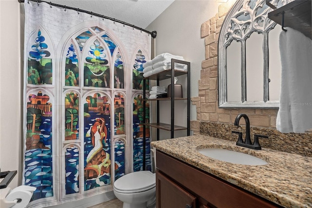 bathroom featuring vanity, toilet, and a textured ceiling