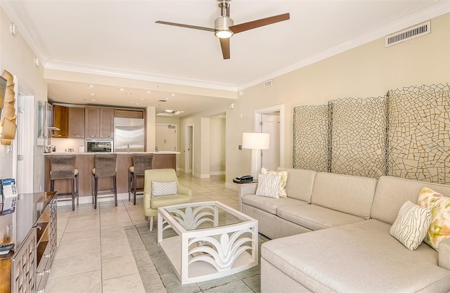 living room with light tile patterned flooring, crown molding, and ceiling fan