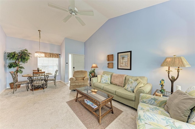 carpeted living room featuring ceiling fan with notable chandelier and high vaulted ceiling