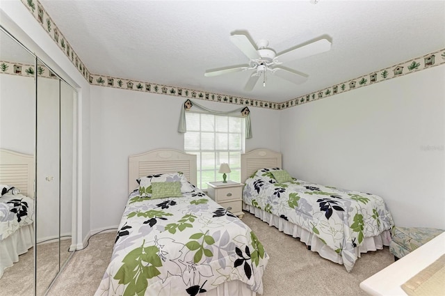 carpeted bedroom featuring ceiling fan, a closet, and a textured ceiling