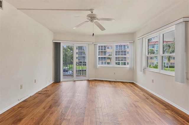 unfurnished room with hardwood / wood-style floors, ceiling fan, and a wealth of natural light