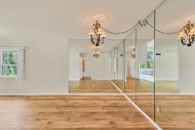 interior space featuring plenty of natural light, hardwood / wood-style floors, and a chandelier