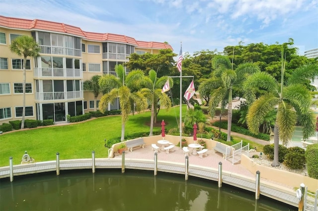 view of dock with a water view and a yard