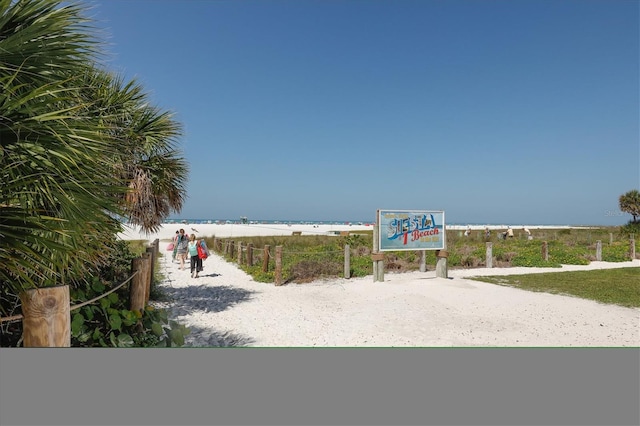 view of home's community with a water view, a beach view, and volleyball court