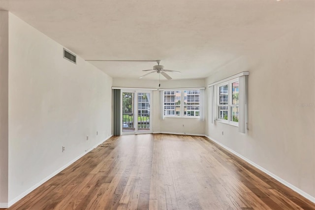 1300 N Portofino Dr Unit 208, Sarasota, FL 34242 - spare room featuring hardwood / wood-style floors, a ceiling fan, and plenty of natural light