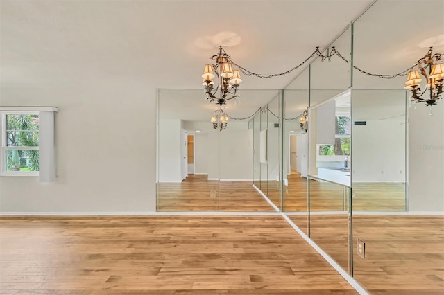 1300 N Portofino Dr Unit 208, Sarasota, FL 34242 - unfurnished dining area featuring a chandelier, wood finished floors, and plenty of natural light