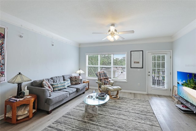 living room with hardwood / wood-style floors, a textured ceiling, ceiling fan, and ornamental molding