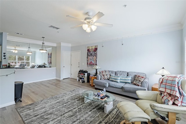 living room featuring crown molding, ceiling fan, and wood-type flooring