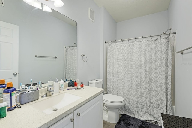 bathroom featuring a shower with curtain, vanity, and toilet