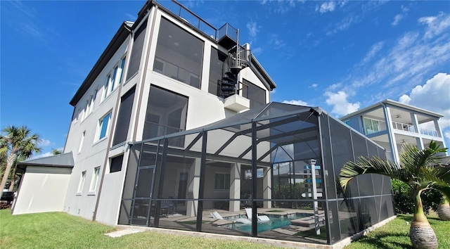 back of property with a pool with hot tub, a balcony, a lanai, and a yard