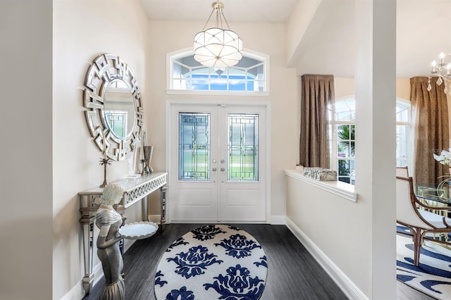 foyer with an inviting chandelier, dark hardwood / wood-style flooring, and french doors