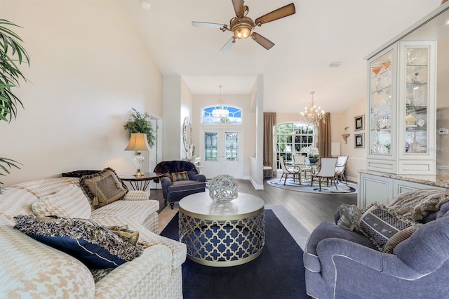 living room featuring hardwood / wood-style flooring, ceiling fan with notable chandelier, high vaulted ceiling, and french doors