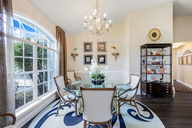 dining area featuring lofted ceiling, dark wood-type flooring, and a notable chandelier