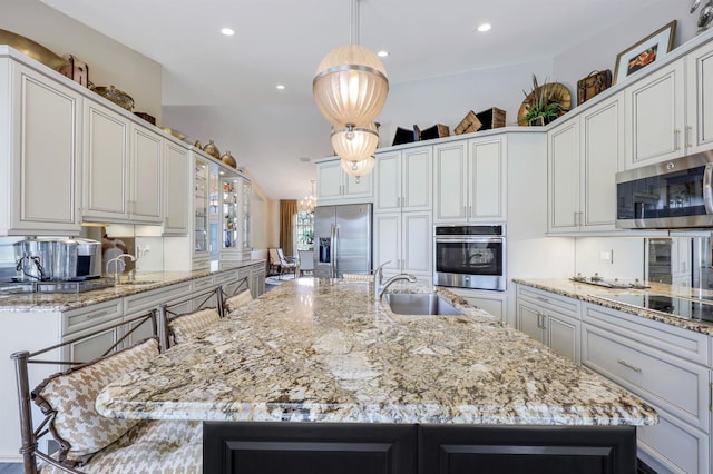 kitchen featuring a spacious island, sink, hanging light fixtures, a kitchen breakfast bar, and stainless steel appliances