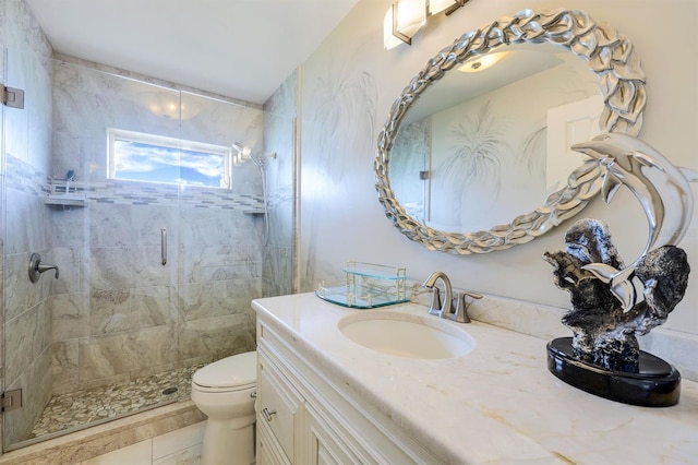 bathroom featuring toilet, vanity, and a shower with shower door