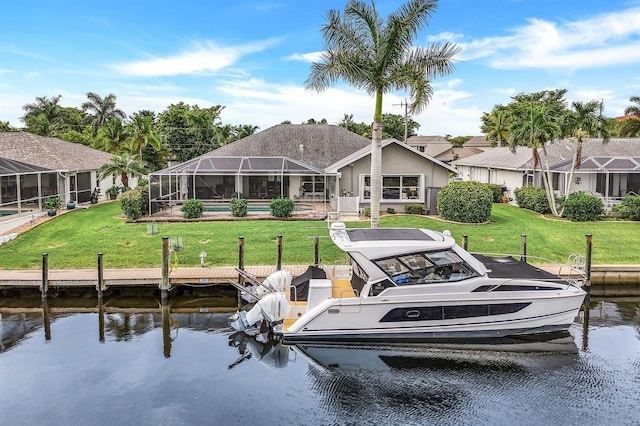 rear view of property with a lanai, a lawn, and a water view