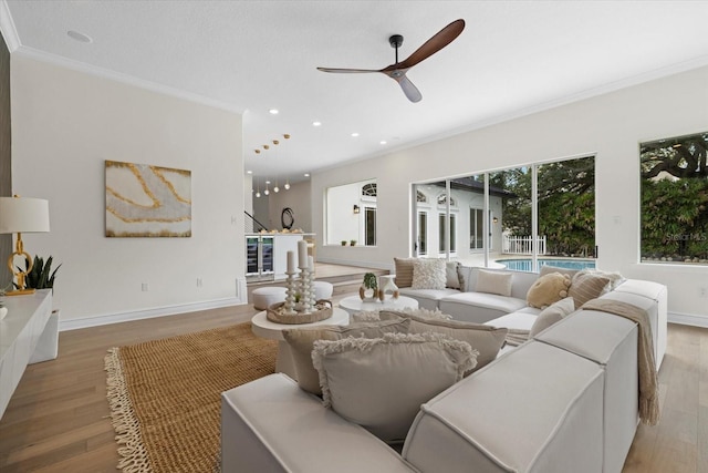 living room featuring ceiling fan, light hardwood / wood-style floors, and ornamental molding