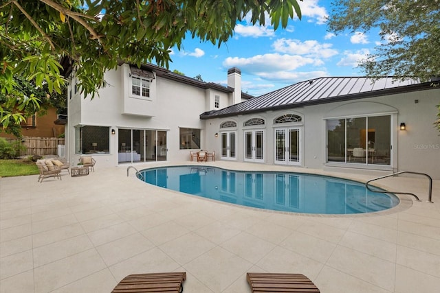 view of swimming pool with french doors and a patio area