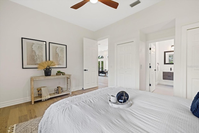 bedroom with ceiling fan, light hardwood / wood-style floors, and connected bathroom