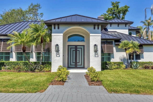 view of exterior entry with a standing seam roof, stucco siding, and metal roof