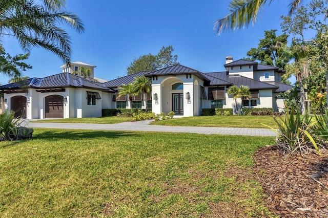 view of front of house featuring driveway, metal roof, a standing seam roof, and a front yard