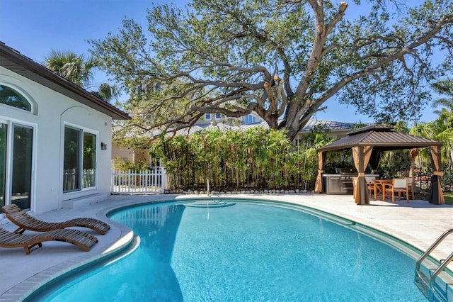 pool with a gazebo, a patio area, and fence