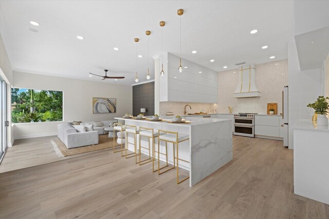 kitchen featuring double oven range, custom range hood, white cabinets, modern cabinets, and tasteful backsplash