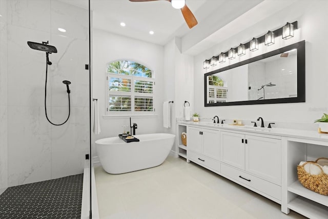 bathroom with walk in shower, double vanity, a freestanding tub, a ceiling fan, and a sink