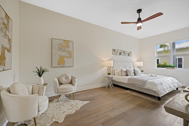 bedroom with ceiling fan, baseboards, and wood finished floors