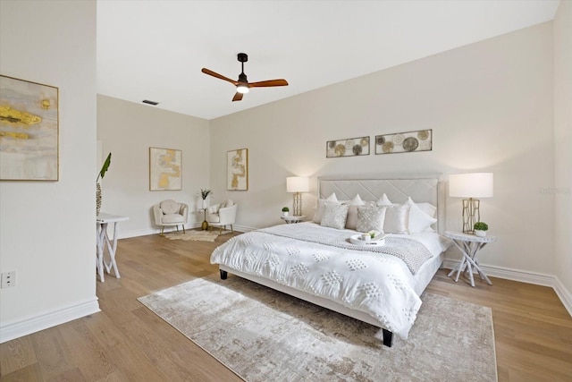 bedroom featuring a ceiling fan, baseboards, and wood finished floors