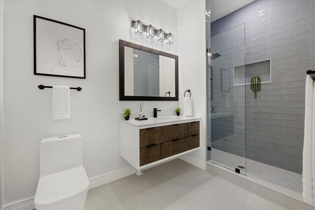 bathroom with vanity, baseboards, a walk in shower, tile patterned floors, and toilet