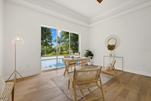 dining space featuring crown molding, baseboards, and hardwood / wood-style flooring