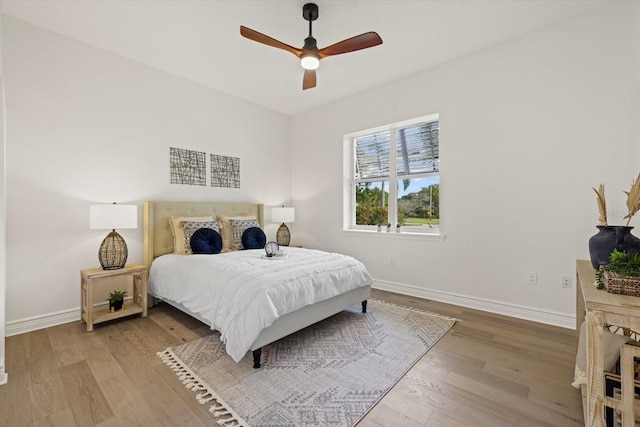bedroom featuring a ceiling fan, baseboards, and wood finished floors