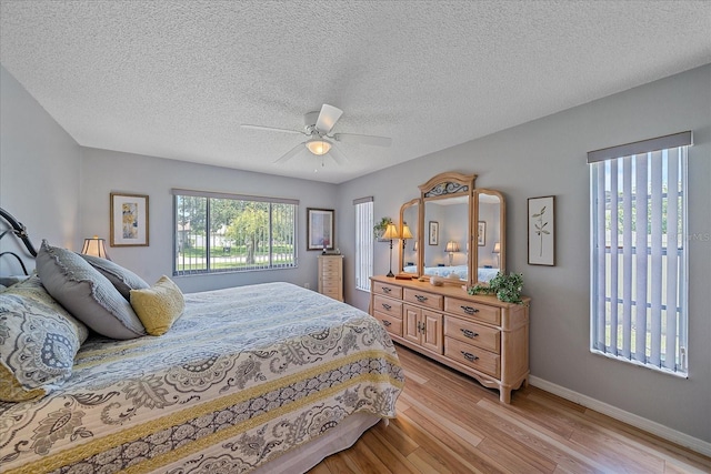 bedroom featuring a textured ceiling, light hardwood / wood-style flooring, and ceiling fan