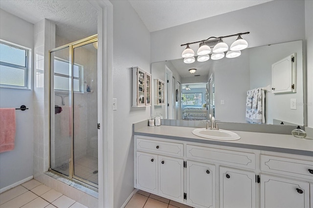 bathroom with a shower with door, vanity, plenty of natural light, and tile patterned floors