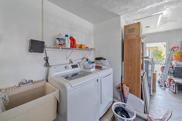 clothes washing area featuring sink, washing machine and clothes dryer, and a textured ceiling