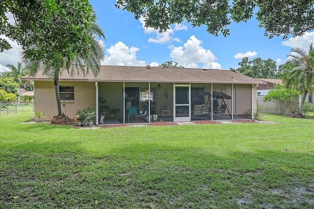 back of house with a sunroom and a lawn