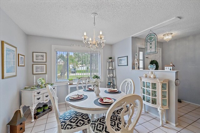 tiled dining room featuring a notable chandelier and a textured ceiling