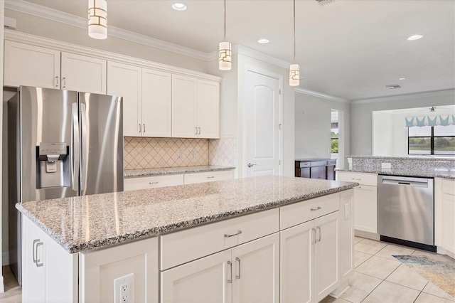 kitchen featuring backsplash, stainless steel appliances, decorative light fixtures, white cabinets, and a center island