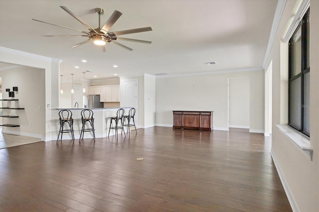 living room featuring ceiling fan, dark hardwood / wood-style floors, ornamental molding, and sink