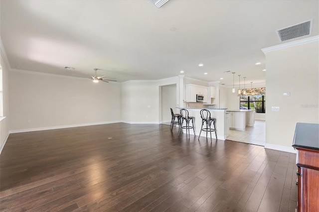 living room with dark hardwood / wood-style floors, ceiling fan, and crown molding