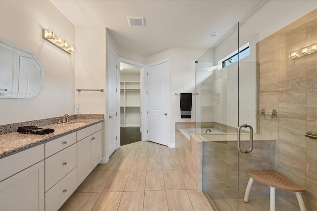 bathroom featuring tile patterned flooring, vanity, and a shower with shower door