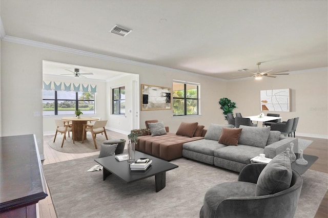 living room featuring hardwood / wood-style flooring, ceiling fan, and crown molding