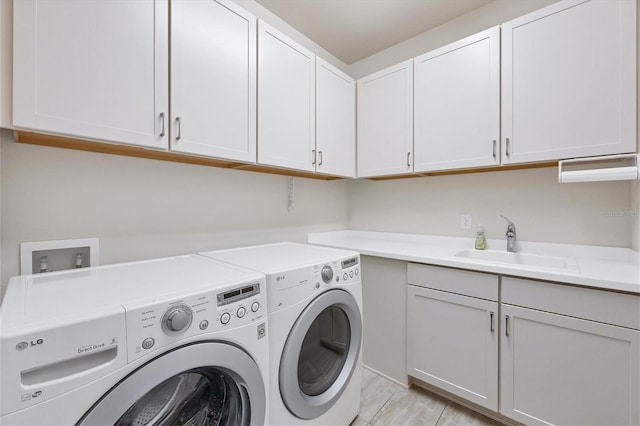 laundry room featuring cabinets, washer and clothes dryer, and sink